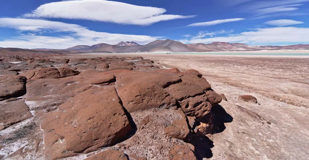 Turquoise lagoon against red rocks at Piedras Rojas on a full-day Atacama Desert tour in the Chilean altiplano